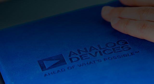 A hand touching to a book with an Analog Devices logo on it