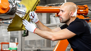 Engineer repairing an automatic robot arm in automotive, smart factory