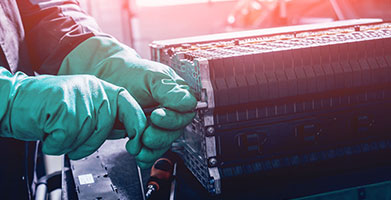 Worker dismanteling an EV battery