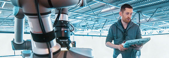 Engineer operates a robotic arm via his tablet computer