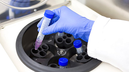 Scientist placing a tube to centrifugation instrument