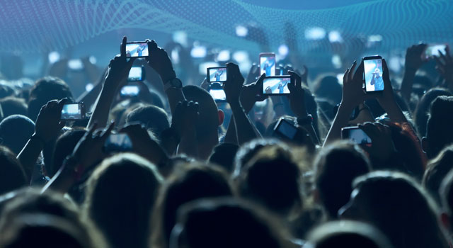 People filming with smartphones during a concert