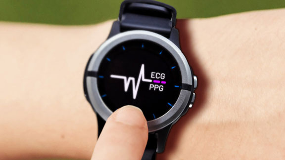 Close-up of smartwatch displaying ECG and PPG monitor screen, finger touching side button.