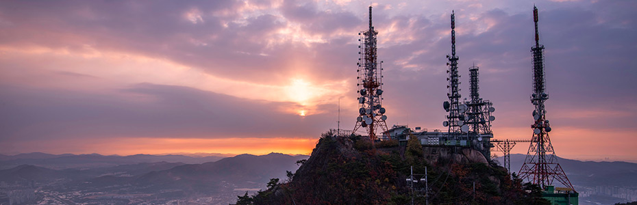 Communication towers on a hill at sunset