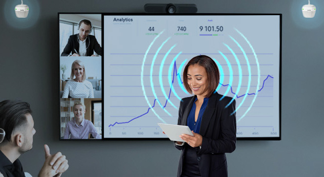 A woman with blue sound waves coming from her mouth as she presenting during a meeting and a pair of biam speakers detecting her voice.