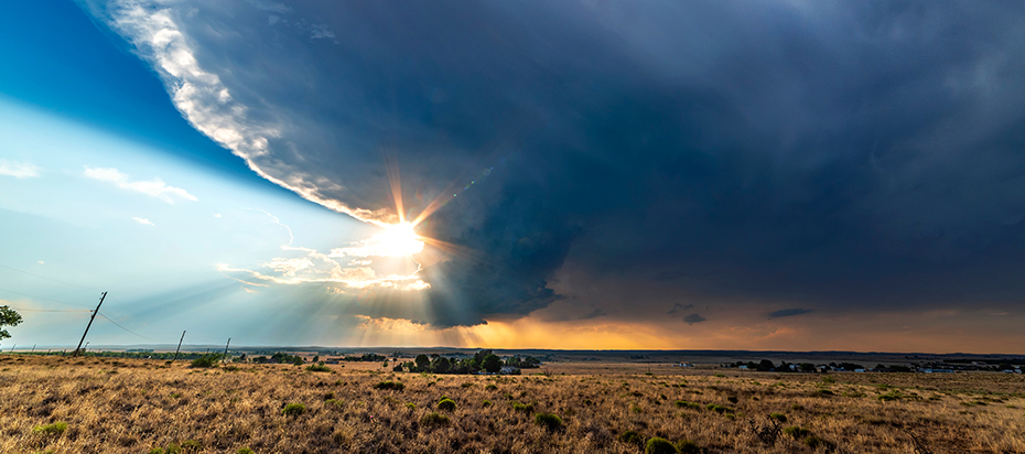 Image of dark clouds after a storm. Sun rays are peaking through to reveal clear skies.