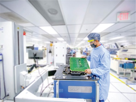 Figure 1. Operator mounting load board on tester for testing digital SoC.