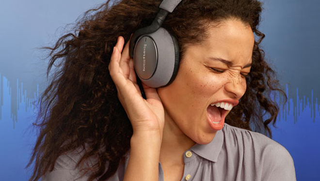 Woman signing while wearing headphones and an audio signal graphic displays in the background.
