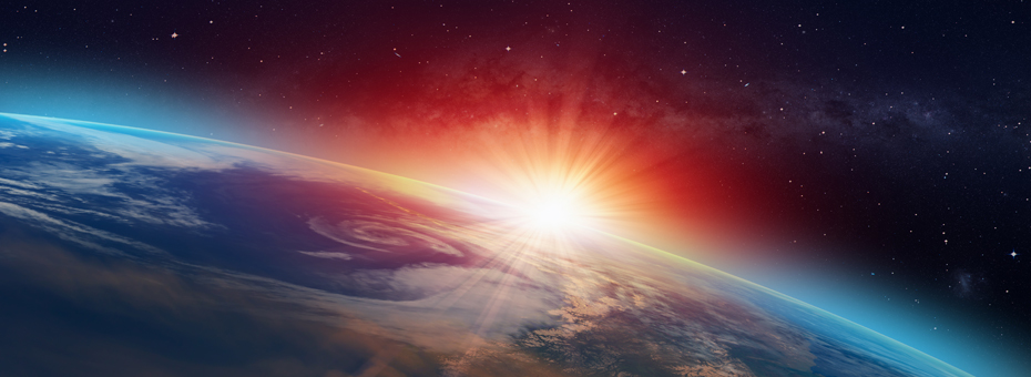 Image shows low orbit of earth from outer space with bright sun rays from behind planet Earth.
