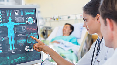 A doctor pointing to a medical chart on a digital screen